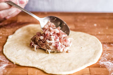 homemade raw meat pie on a wooden tableの写真素材