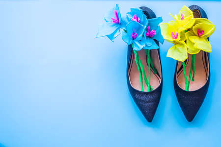 lady's high heels and paper flowers on blue background, top viewの写真素材