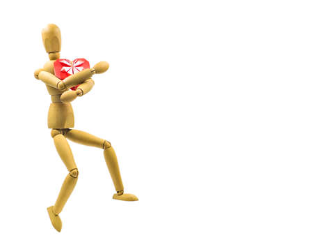 women's day and valentine day concept. wooden puppet with red paper heart isolated on white backgroundの写真素材