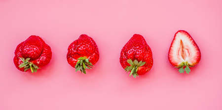 raw of fresh juicy strawberries on pink background. flat lay top viewの写真素材