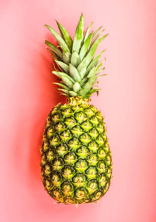 fresh juicy pineapple lays on pink background