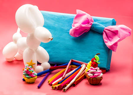 party concept. balloon dog, clay cupcakes and balloons on bright pink backgroundの写真素材