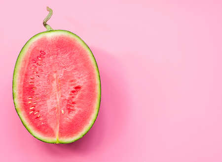 creative layout of fruit. a watermelon half on pink backgroundの写真素材