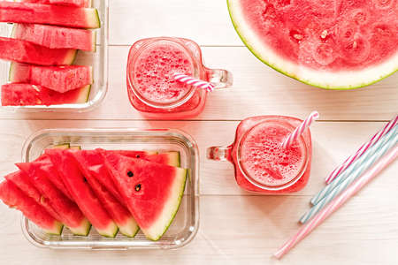 summer drinks concept. watermelon slices and smoothies in mason jar on white wooden background top view.の写真素材