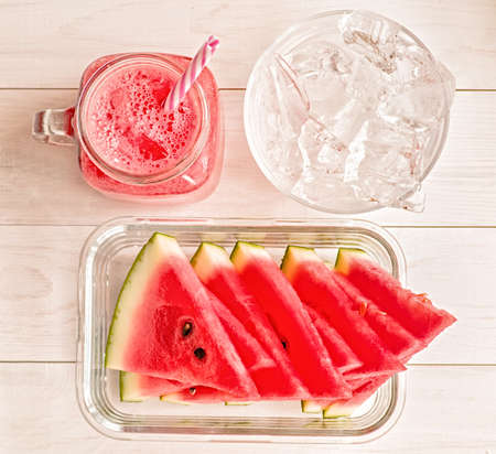 summer drinks concept. watermelon slices and smoothies in mason jar on white wooden background top view.の写真素材