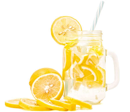 lemonade in a mason jar with a drinking straw decorated with slices of lemon isolated on whiteの写真素材