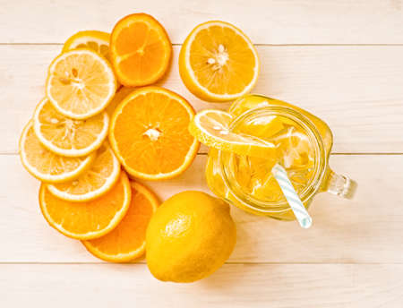 lemonade in a mason jar with a drinking straw decorated with slices of citrus oranges and lemon top view on wooden backgroundの写真素材