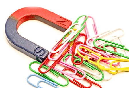 U-shaped red and blue magnet attracting paper clips isolated on white backgroundの写真素材