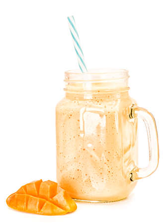 mango milkshake in mason jar with drinking straw decorated with mango half isolated on white backgroundの写真素材