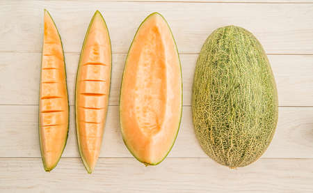 melon slices in a raw on white wooden backgroundの写真素材