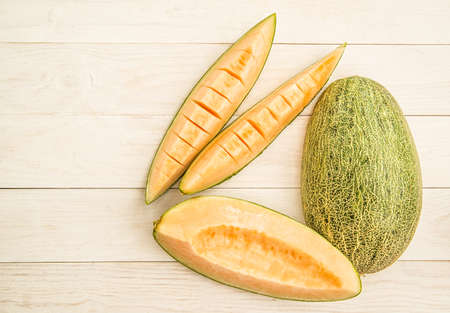 organic melon slices on white wooden backgroundの写真素材