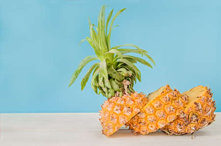 creative layout. summer fruit concept. cut pineapple on white wood with blue backgroundの写真素材