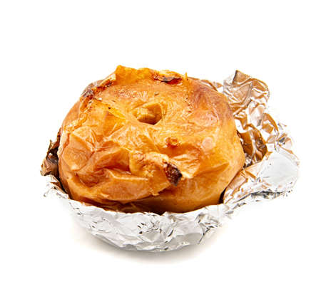 thanksgiving and christmas concept. Baked apple in aluminum foil isolated on whiteの写真素材