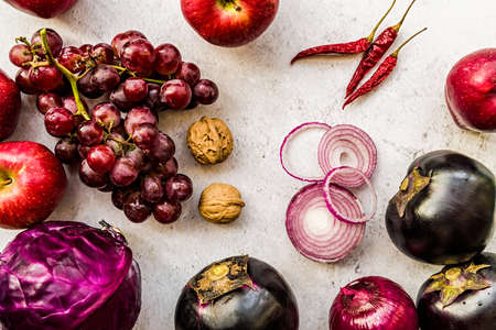 raw purple vegetables and fruit on white wooden background top viewの写真素材