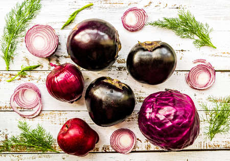 raw purple vegetables on white wooden background top viewの写真素材