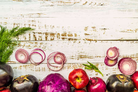 raw purple vegetables and fruit on white wooden background top viewの写真素材