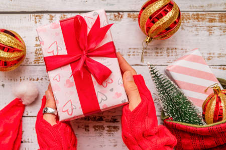 Christmas present with female hands on white rustic backgroundの写真素材