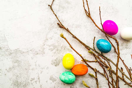 Easter holiday concept. pussy willow branches with colored eggs on white marble background, copy space, top viewの写真素材
