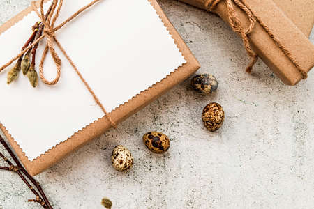 Easter gifts in craft paper, eggs and pussy-willow branches on marble background flat lay top viewの写真素材