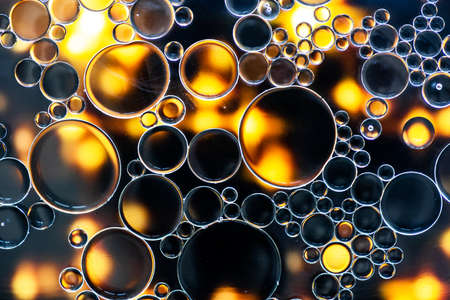 Abstract background. Black and yellow oil bubbles on water surface