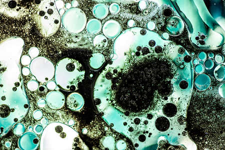 Bright blue bubbles with black ink on water surface in abstract background