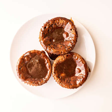fresh homemade chocolate muffins with topping on white plate top viewの写真素材