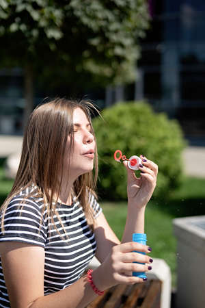 True happiness concept. Young caucasian woman outdoors blowing soap bubbles in a sunny dayの写真素材