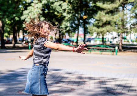 True happiness concept. Happy smiling caucasian woman in casual clothes having fun dancing in the park in summer dayの写真素材