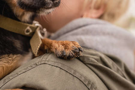 caucasian woman holding a paw of her dog
