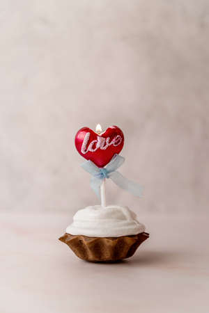 Valentines day concept. Sweet cupcake with a love candle on white background front viewの写真素材