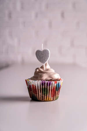 birthday cupcake on white table with hard lightの写真素材