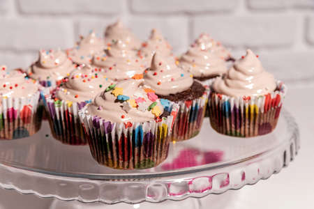 Birthday concept. Delicious cupcakes with colorful decorations on cake plate. Horizontal...