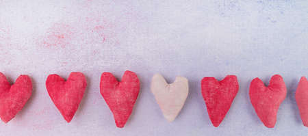 Row of hand made fabric hearts craft top view on pink backgroundの写真素材