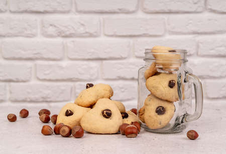 Valentine's Day concept. Homemade heart shaped cookies with nuts in a mason jar front view with copy...
