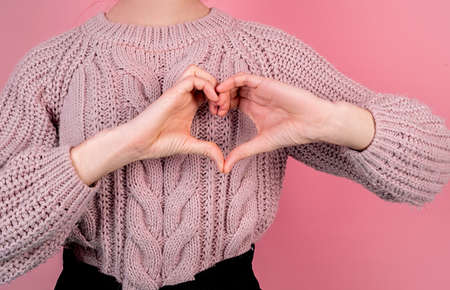 Valentine's Day concept. Young woman forming a heart with her handsの写真素材