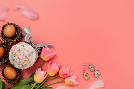 Easter concept. Easter cake with tulips and eggs on pink background top view flat lay with copy...
