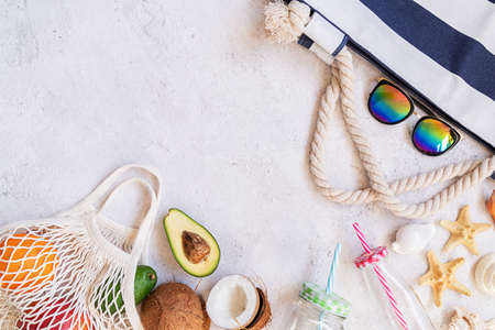 Summer vibes flat lay. Beach hat, sunglasses and fruit top view with copy space