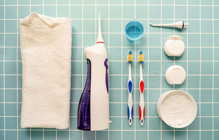 Dental tools, floss, mouth irrigator, toothbrushes and tooth powder top view on blue backgroundの写真素材
