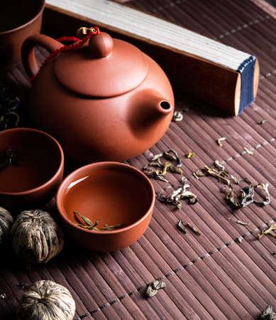 Asian teapot with cups and green tea on wooden placemat copy spaceの写真素材