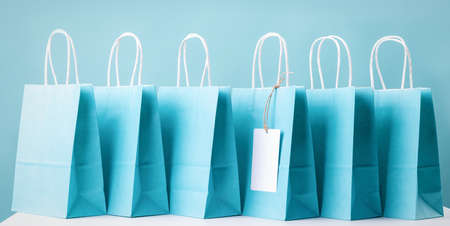 shopping concept. Blue paper shopping bags standing in line on the tableの写真素材