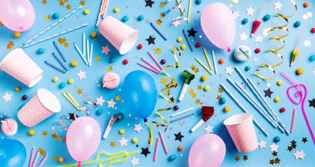 Birthday party background. Balloons, candles, confetti, candies and party supplies on blue, top view flat lay bannerの写真素材