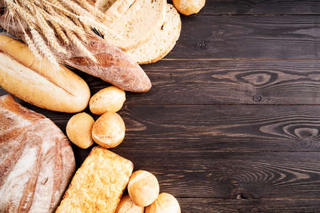 Various kinds of bread on dark wooden table flay lay top viewの写真素材