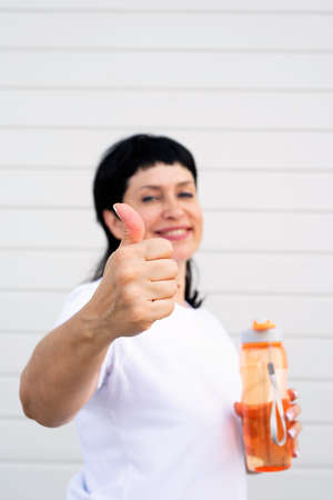 Sport and fitness. Senior sport. Active seniors. Smiling senior woman showing thumbs up after...