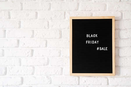 Black friday, seasonal sale concept. Text black friday sale on black letter board on white brick...