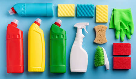 cleaning and housekeeping. collection of various sanitary bottles and cleaning tools on solid blue background top view flat lay. Knollingの写真素材