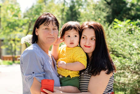 Multiethnic family. A multi generation portrait of a happy grandmother with her daughter and...