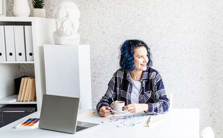 Creative woman artist painting a picture working in her studio