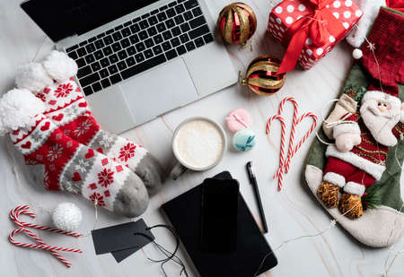 Christmas desktop with laptop, tablet and smart phone surrounded by stockings, candy canes and coffee, top view flat lay, copy spaceの写真素材