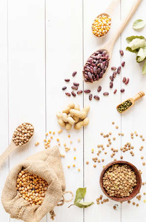 Various dried legumes top view flat lay on white wooden background