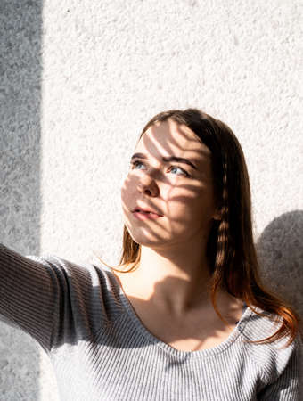 Light and shadow portrait. Beautiful young woman with a shadow pattern on the face in the form of...